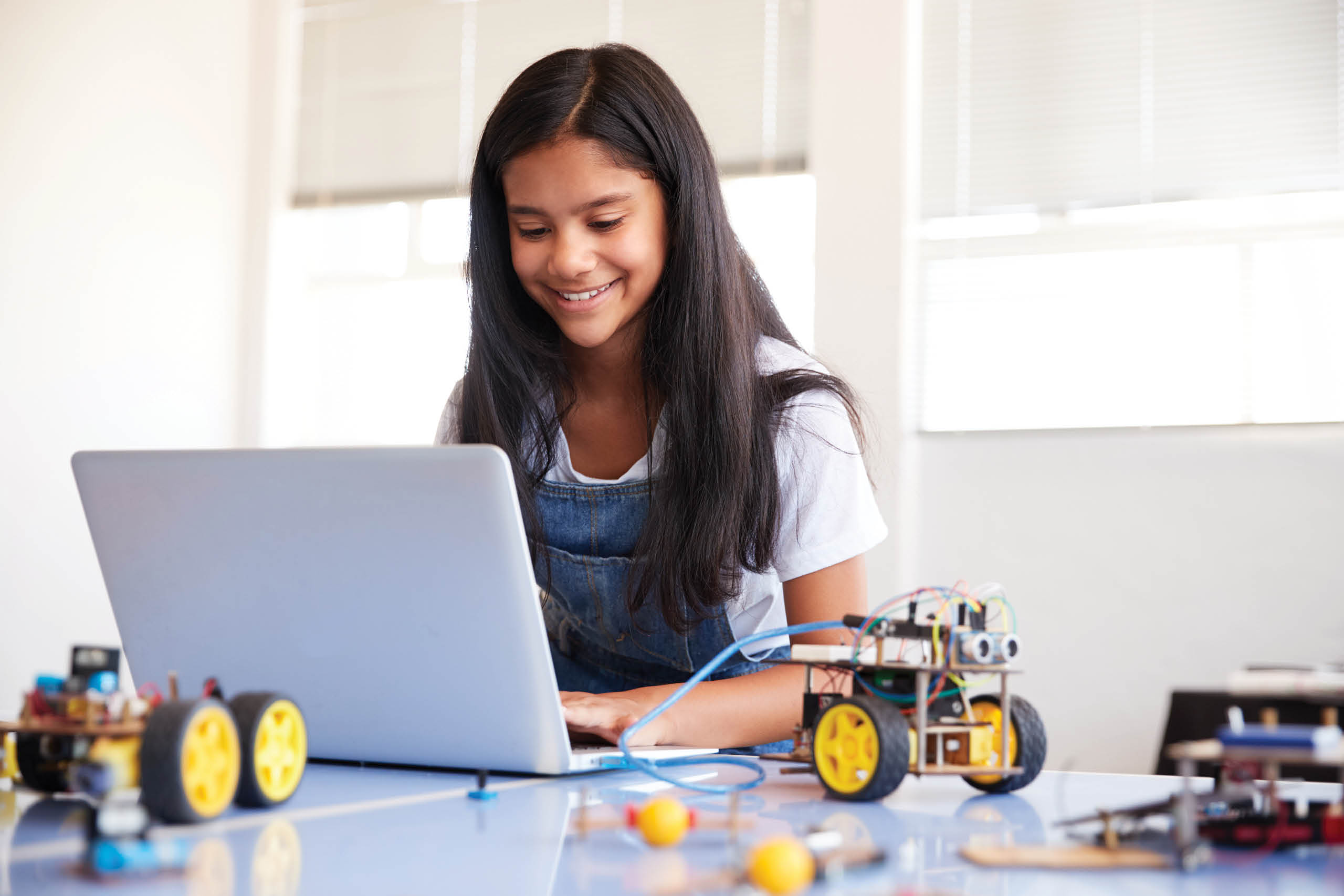 young girl in front of computer with robots