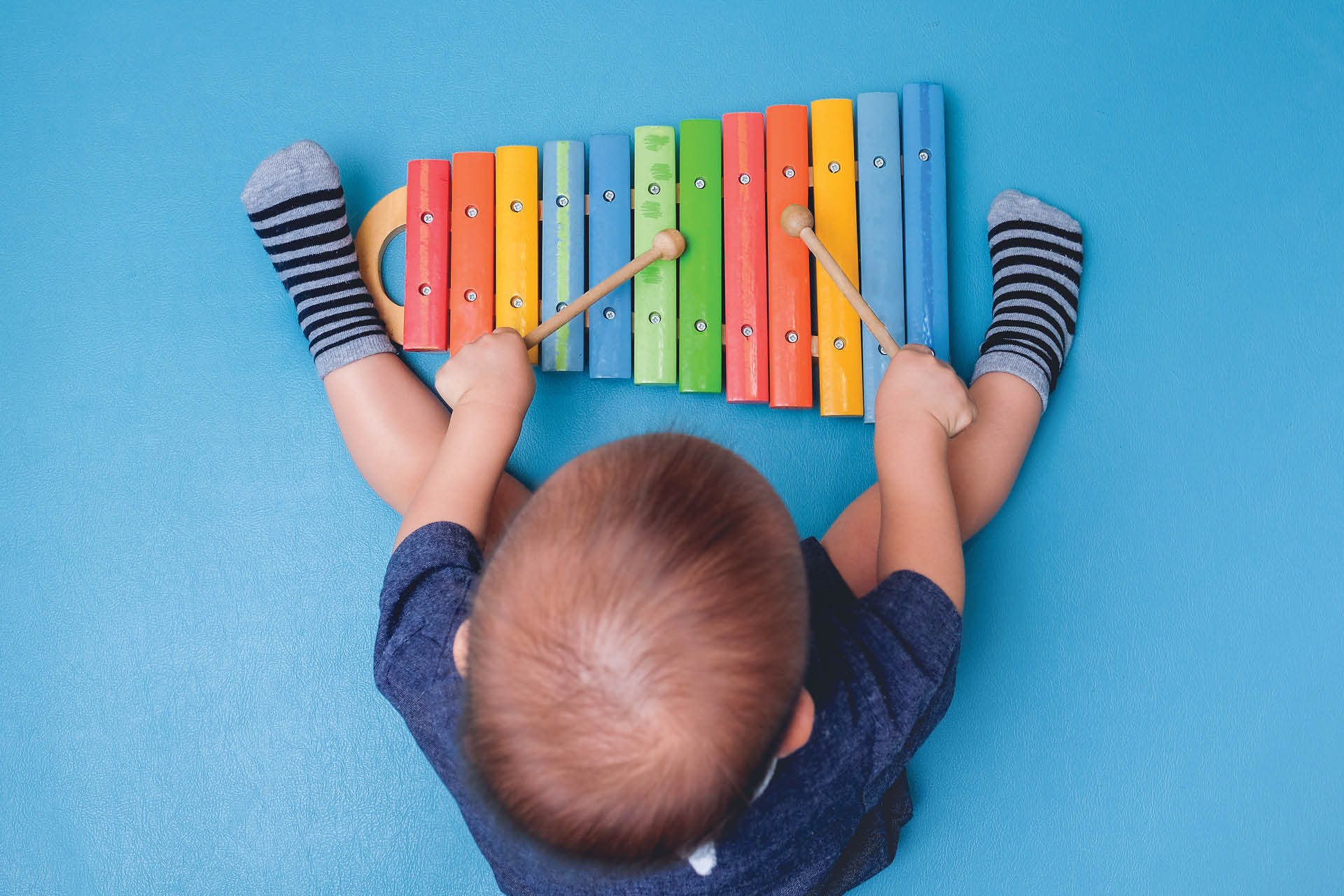 Toddler playing on xylophone